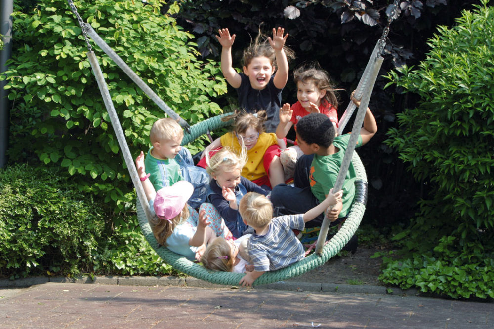 Behinderte und nichtbehinderte Kinder in der Schaukel