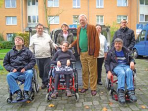 Eine Gruppe Behinderter und Nichtbehinderter Menschen vor dem PKW mit behindertengerechten Umbau